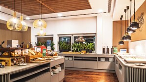 Una cocina moderna con piso de madera, iluminación colgante y un bufé con diferentes opciones de comida.