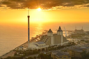 A coastal hotel with a prominent tower, a large building with multiple towers, and a pier extending into the water. - Fullon Hotel Tamsui Fisherman's Wharf (New Taipei City)