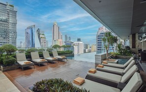 Una piscina al aire libre, sombrillas, tumbonas