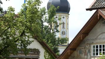 A traditional building with a clock tower, ivy-covered walls, and a mural.