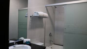 A modern bathroom with a glass-enclosed shower, a white sink, and a black countertop.