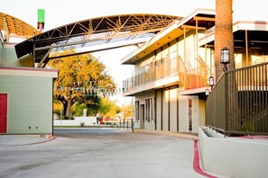 A modern building with a curved roof structure, large windows, and a gated entrance.