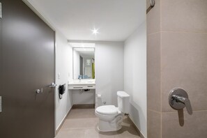 Uma casa de banho moderna com sanita, lavatório e chuveiro.