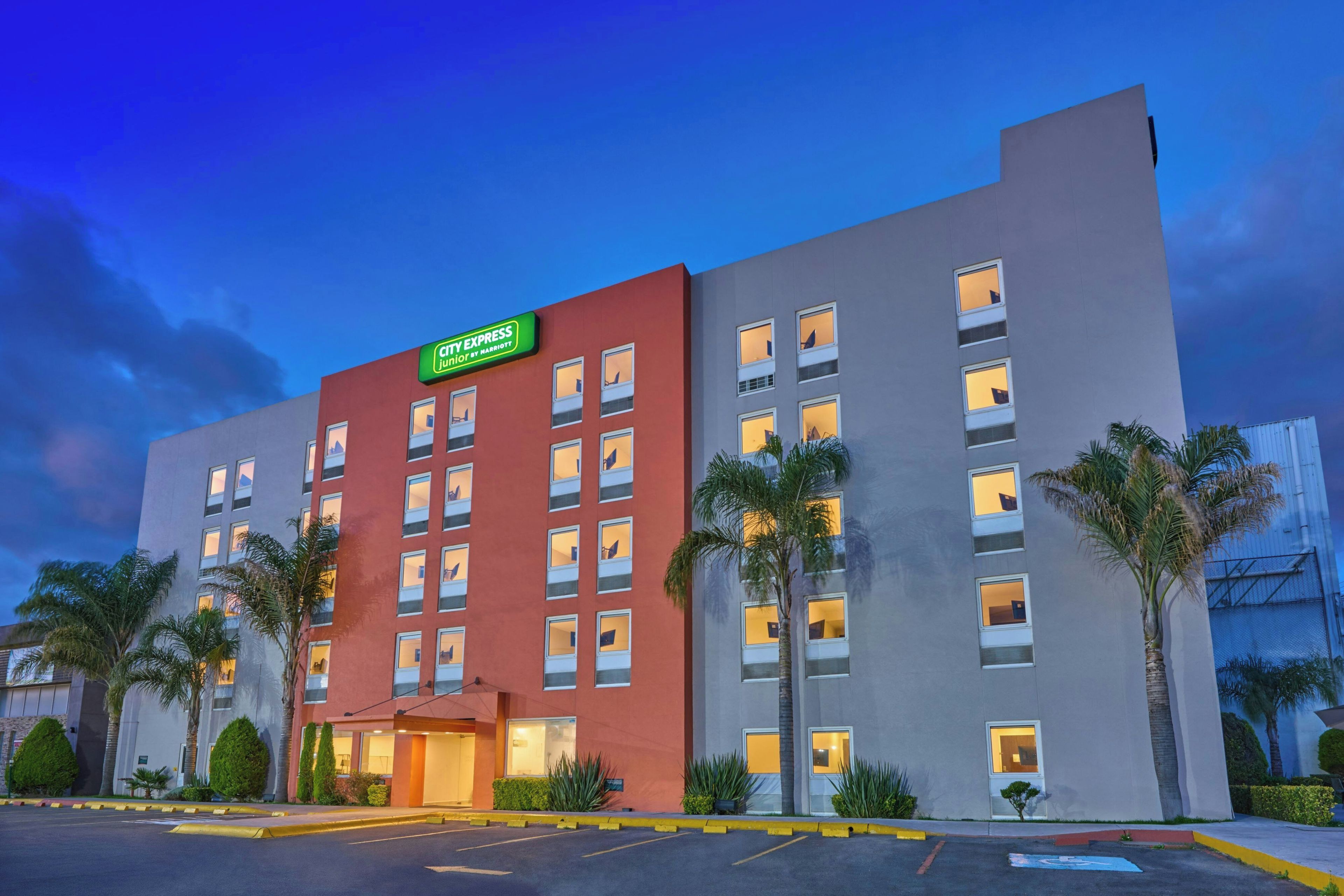 A multi-story hotel with a prominent sign for 'City Express junior by Marriott' on the facade.