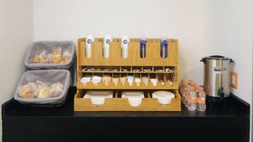 A breakfast bar with bread, condiments, and bottled water.