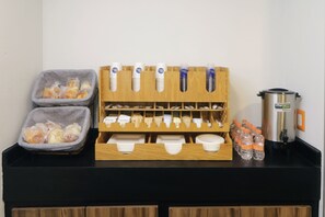 Un buffet pour le petit-déjeuner avec du pain, des condiments et de l’eau en bouteille.