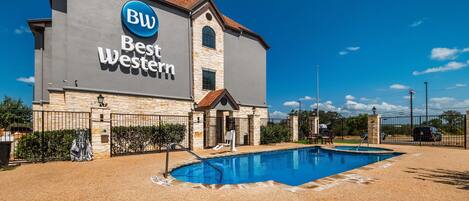 Un hotel Best Western con piscina y fachada de piedra.
