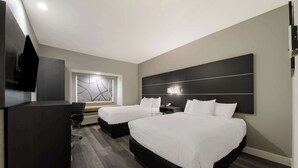 A modern hotel room with two beds, a desk, and a TV. - Best Western SeaWorld San Antonio (San Antonio)