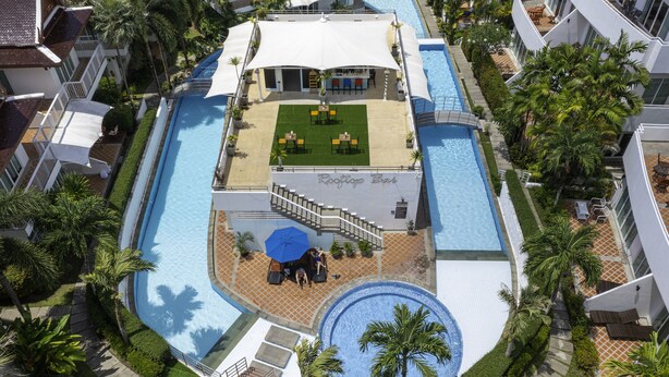 A rooftop pool area with a bar, seating, and palm trees. - Phunawa Resort Karon Beach Phuket (Karon)