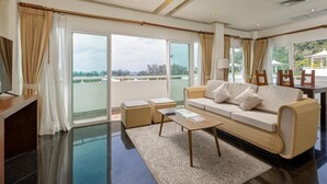 A modern living room with a sofa, coffee table, and a view of the outdoors. - Phunawa Resort Karon Beach Phuket (Karon)
