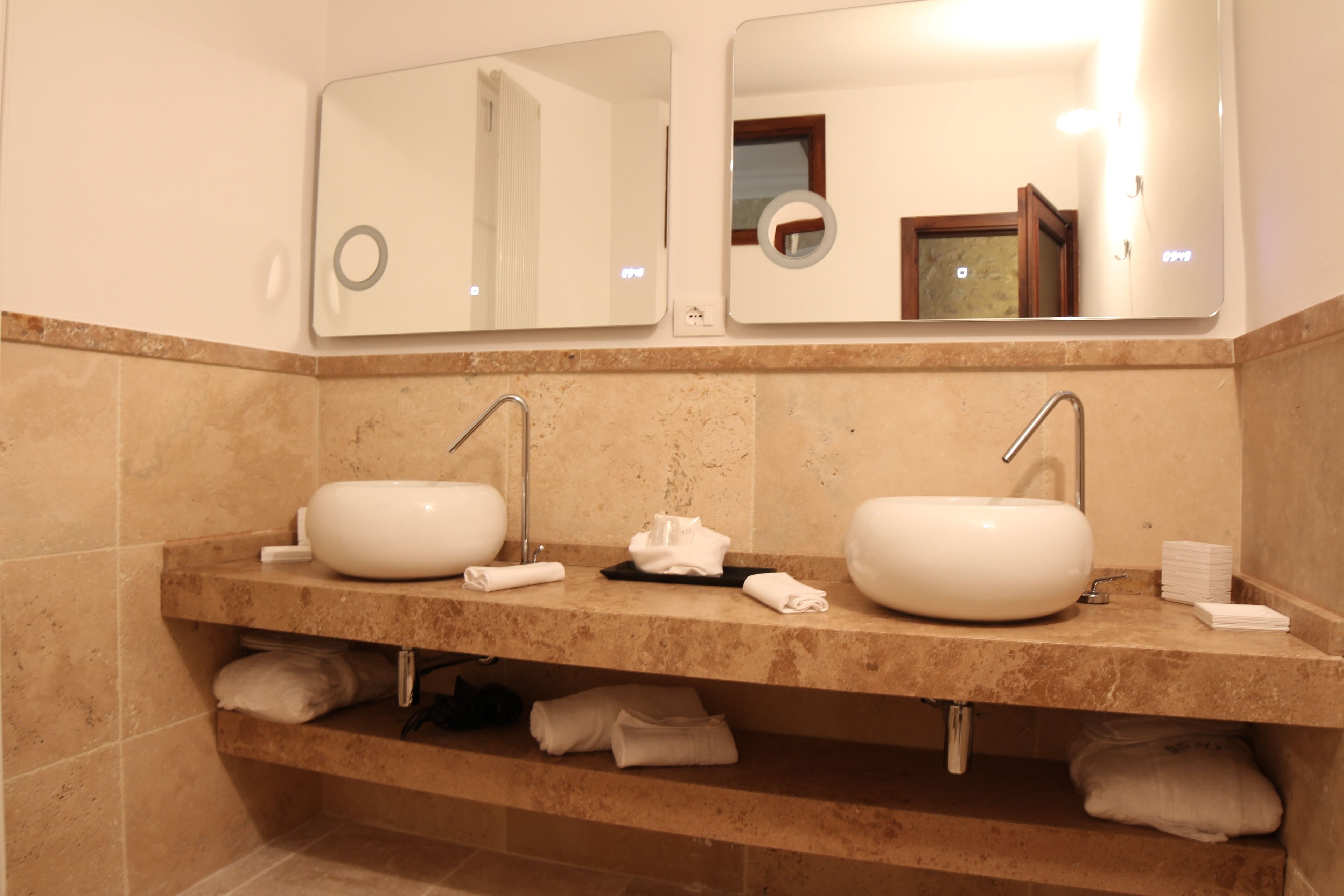 A bathroom with two sinks, a mirror, and a towel rack.