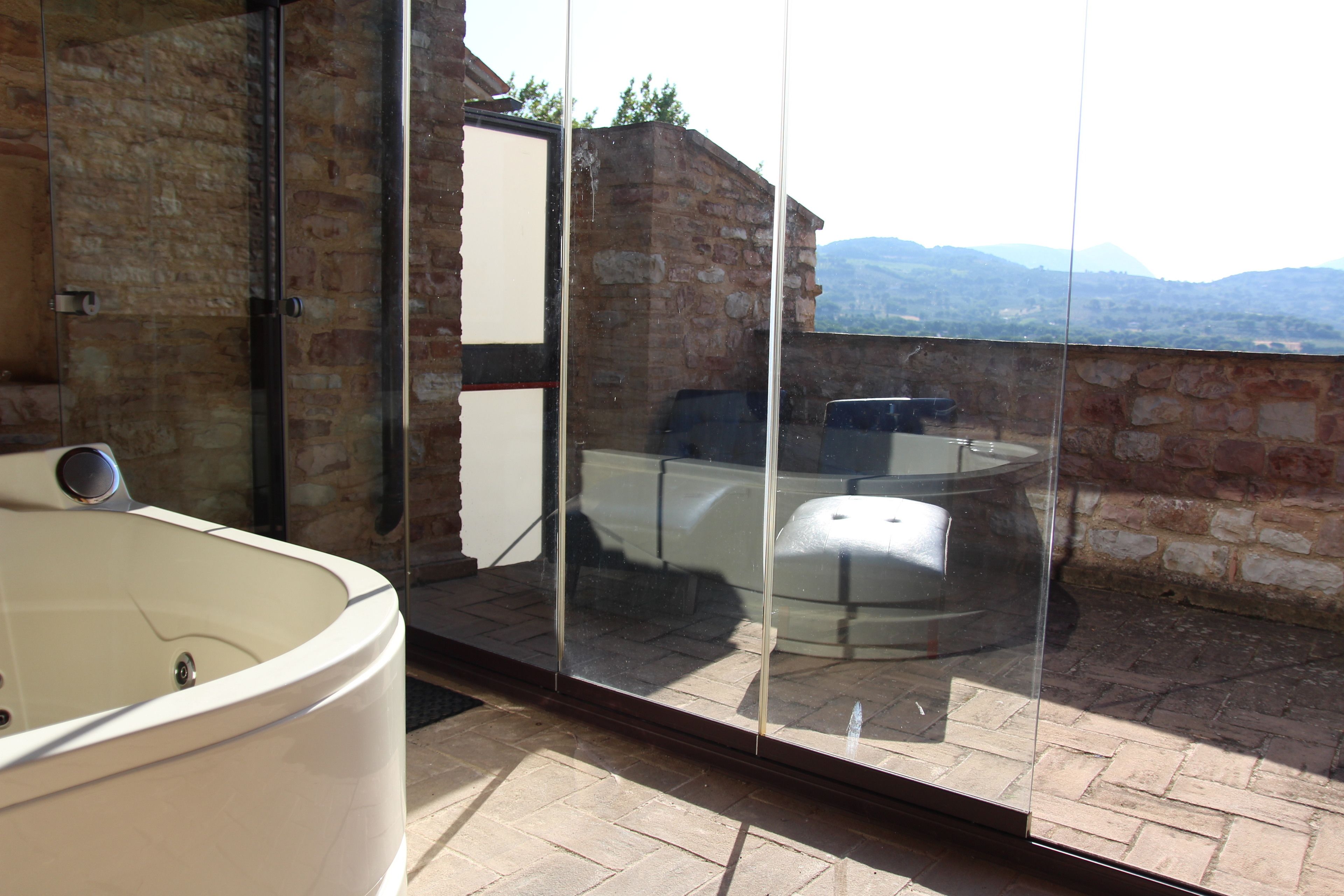 A bathroom with a glass-enclosed shower and a large bathtub.
