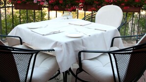 A table set outdoors with a view of hills. - Hotel Ristorante La Bastiglia (Spello)