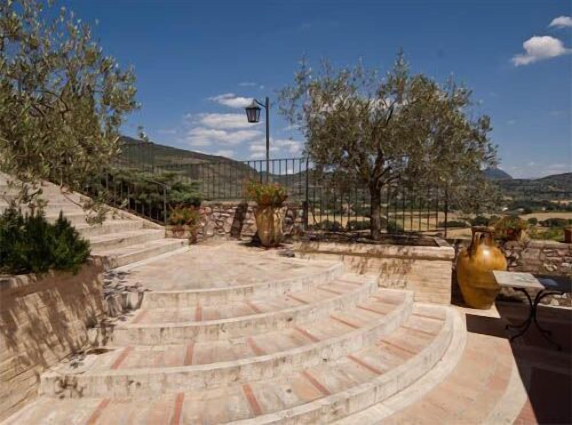 Una escalera de piedra que lleva a una terraza con vistas al campo.