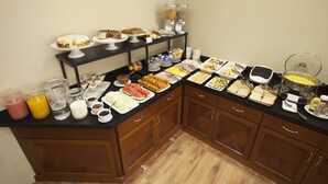 A buffet setup with various food items and beverages.