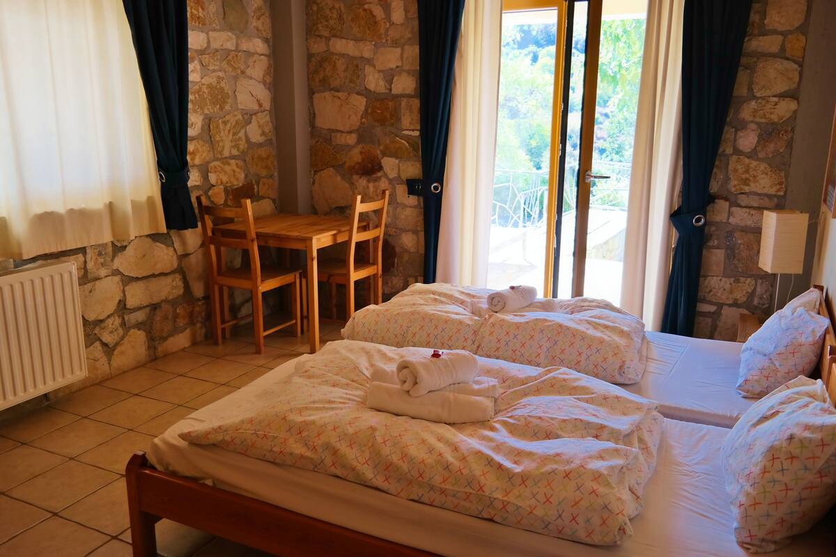 A room with two beds, a wooden table, and chairs.