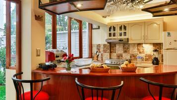 Una cocina con una isla central, taburetes de bar y vistas al exterior.
