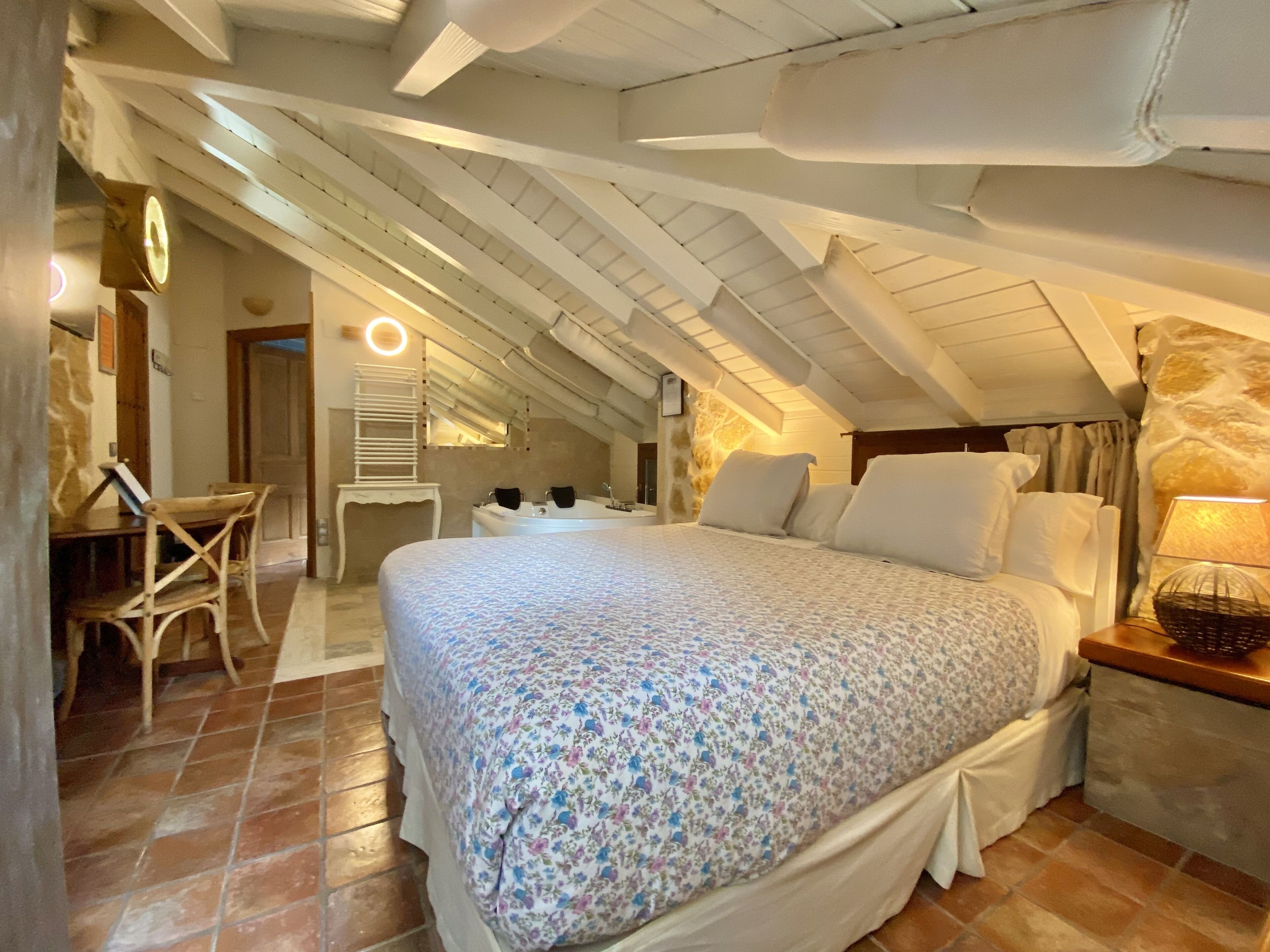 Une chambre avec un grand lit, un bureau et une chaise.