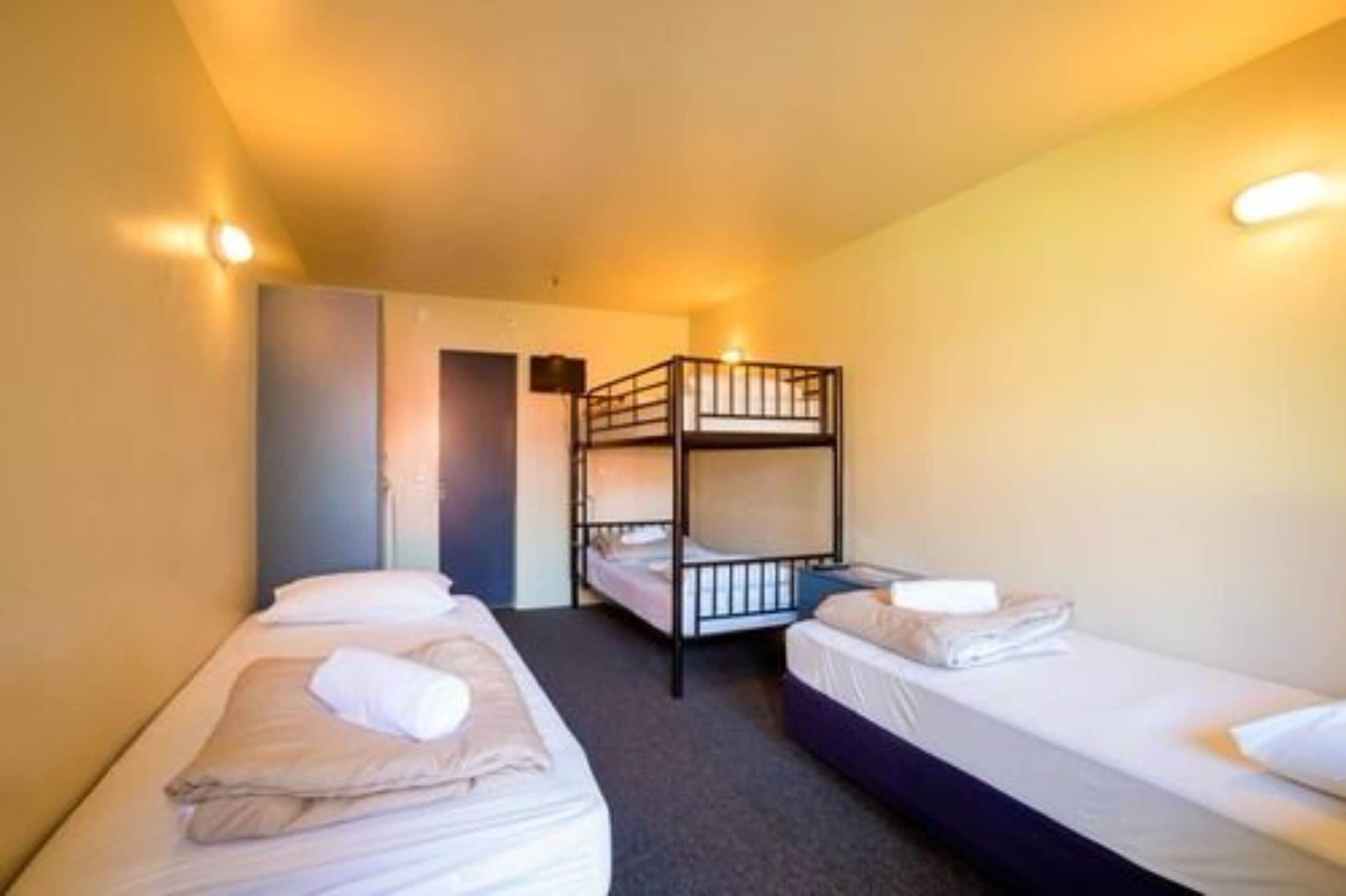 Ein Zimmer mit zwei Einzelbetten und einem Etagenbett.