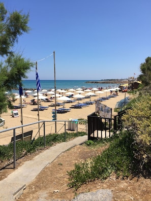 En la playa, camastros, sombrillas y vóleibol de playa
