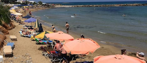 En la playa, camastros, sombrillas y vóleibol de playa