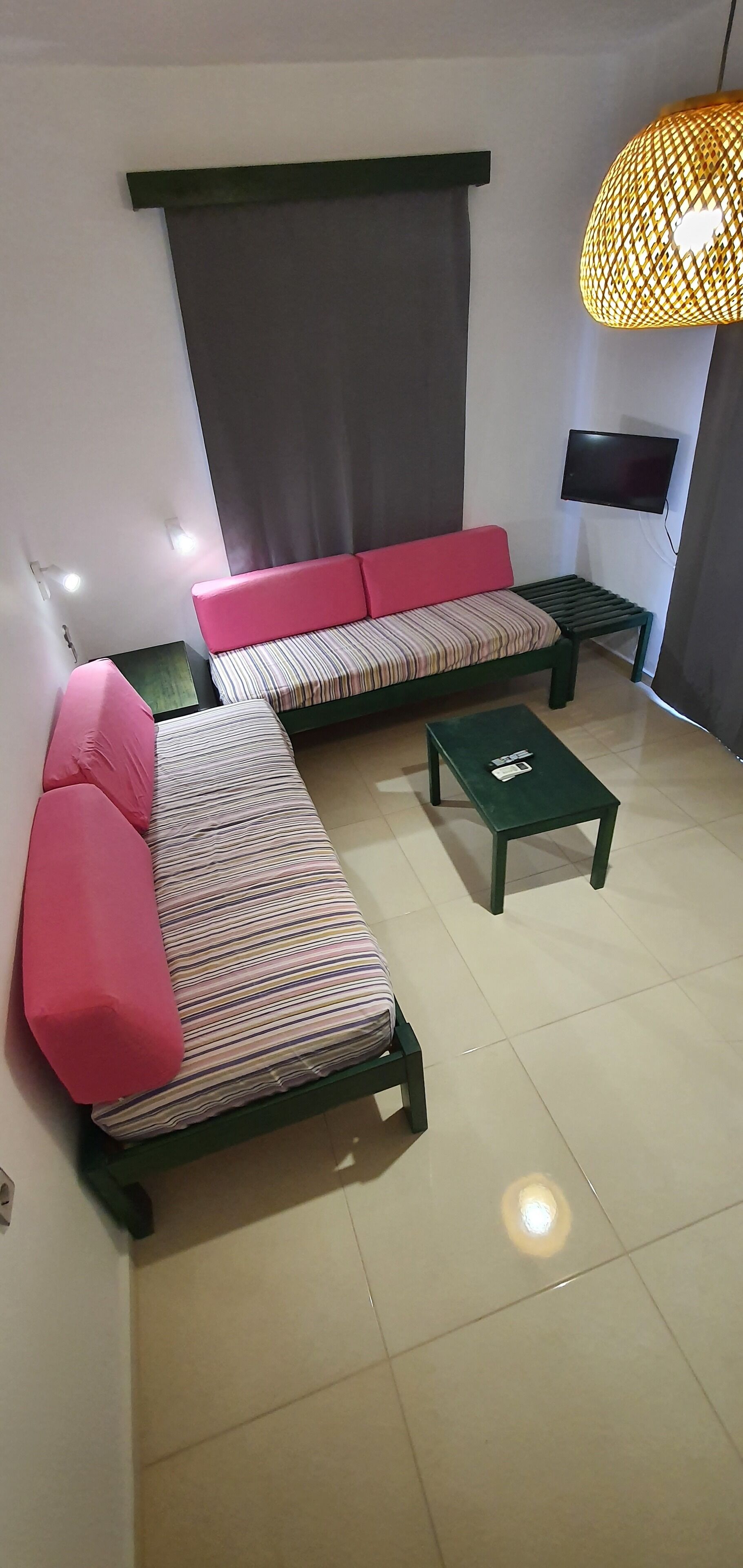 A modern living room with a sofa, a small table, and a television mounted on the wall.
