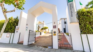 Un ingresso recintato con un cartello che riporta la scritta "Albergue Intuijoven Punta Umbria".