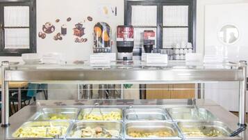 Un espace buffet proposant une variété de plats et des machines à café.