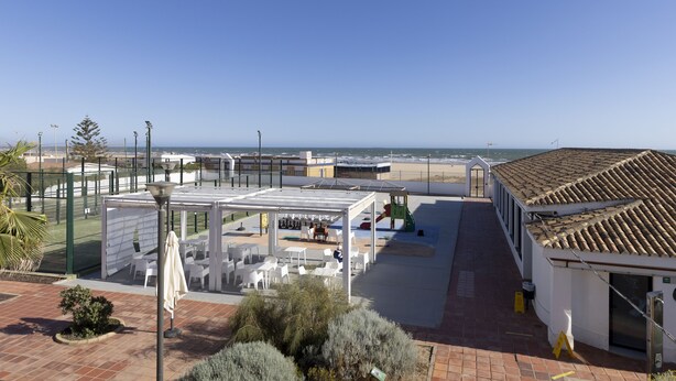 Una terrazza sul tetto con posti a sedere all'aperto, un'area giochi e vista sul mare.