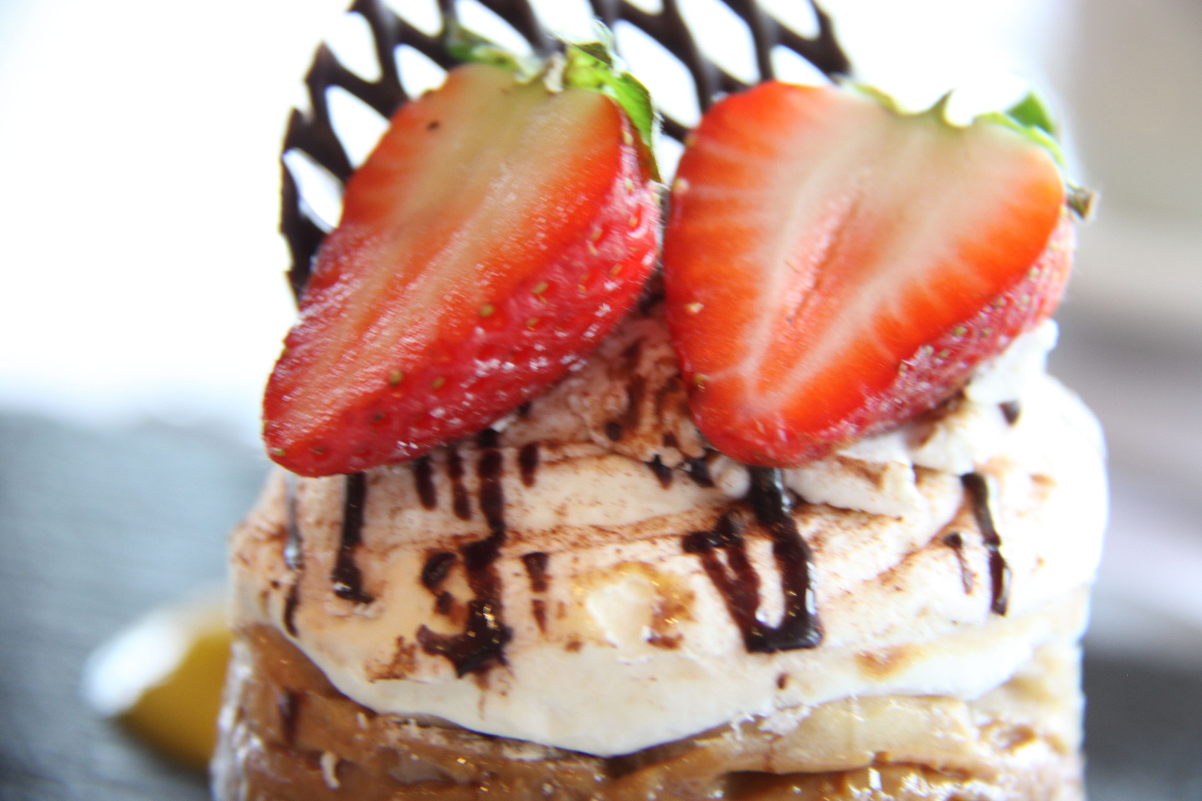 Un postre con fresas y un goteo de chocolate.