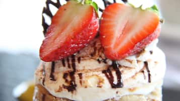 Un postre con fresas y un goteo de chocolate.