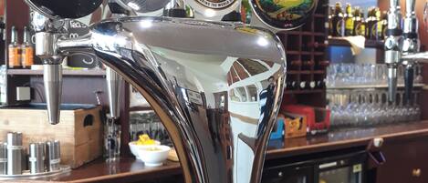 Un robinet de bar avec des étiquettes indiquant les marques de bière suivantes : CARLING, BECK'S VIER, San Miguel et Thatchers Gold.