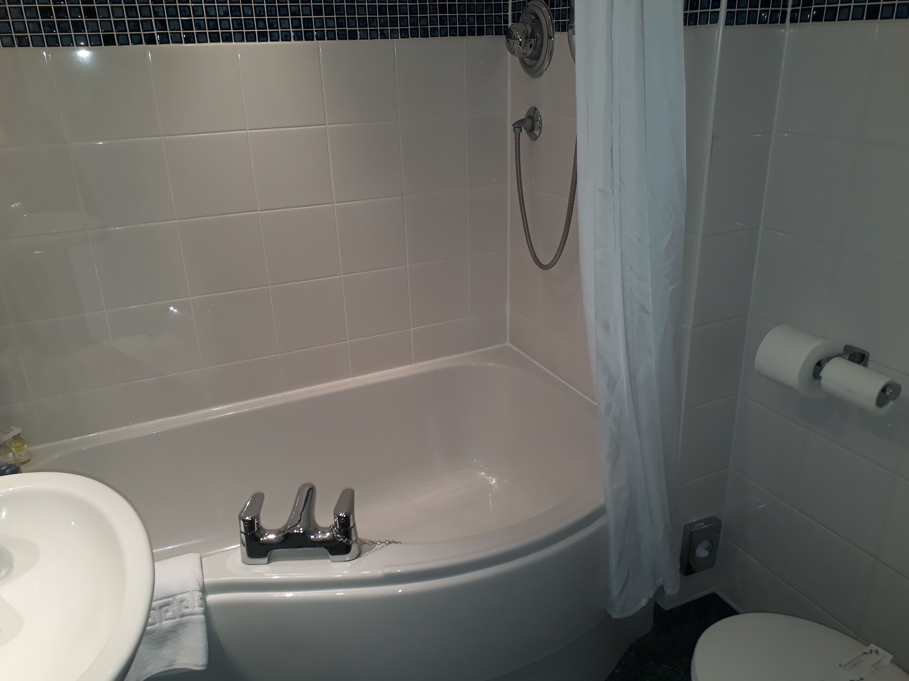 A bathroom with a bathtub, a toilet, and a sink.