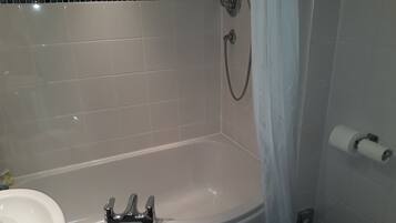 A bathroom with a bathtub, a toilet, and a sink.