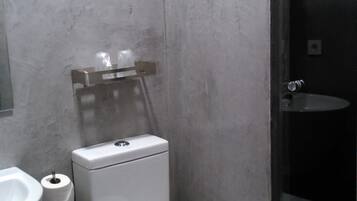 Ein kleines Badezimmer mit Toilette, Waschbecken und Duschkabine.