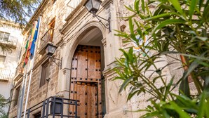 A stone building with an arched entrance, a wooden door, and a metal railing. - Albergue Inturjoven Cazorla - Hostel (Cazorla)