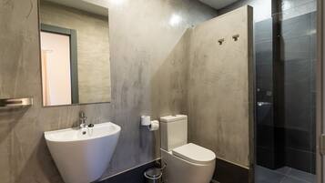 Un baño moderno con lavamanos grande, inodoro y ducha a ras de suelo.