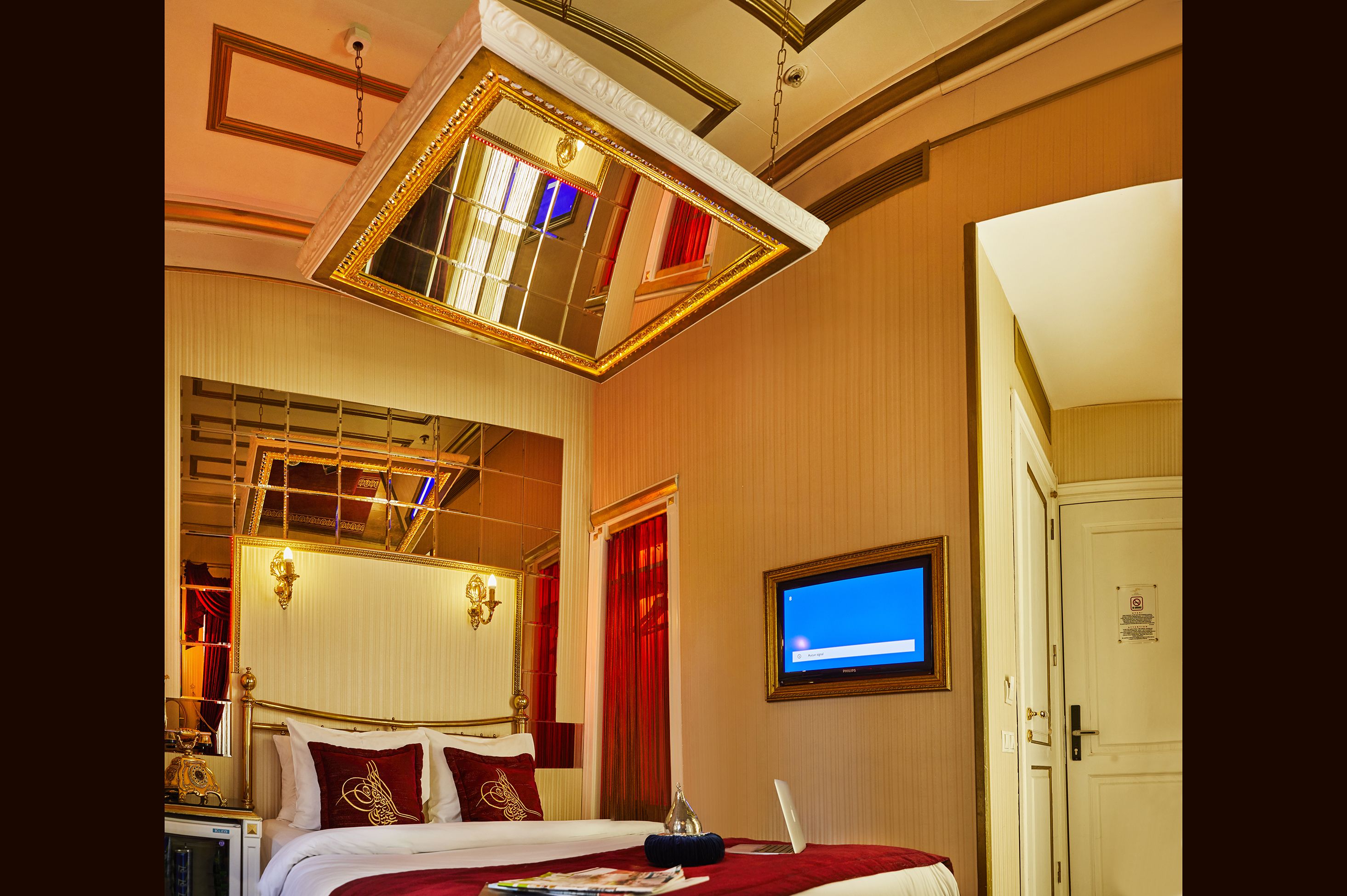 Une chambre d’hôtel avec un grand lit, une télévision et un miroir.