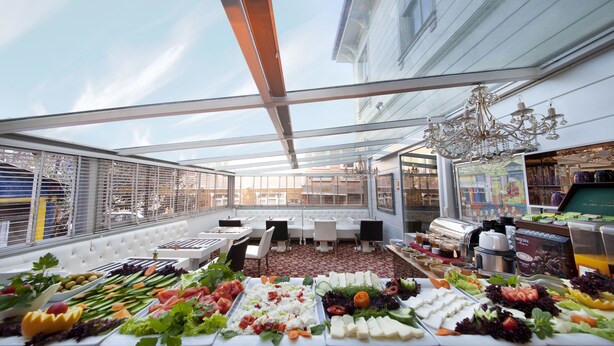 Ein Dachrestaurant mit Glasüberdachung und Blick auf die Stadtlandschaft.