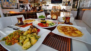 Ein Tisch ist gedeckt mit verschiedenen Gerichten, darunter Gemüse, eine Pizzascheibe und eine Salatschüssel.