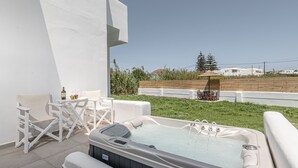 Un bain à remous avec vue sur une zone verdoyante et des bâtiments en arrière-plan.