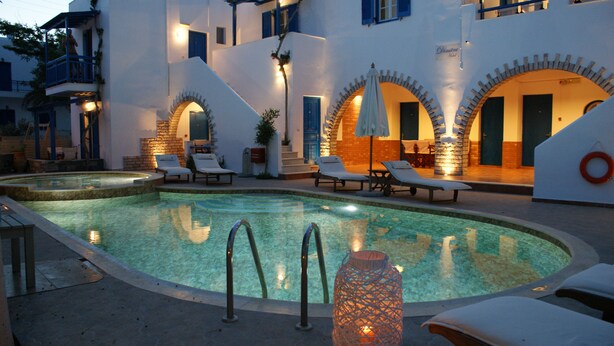 Un espace piscine avec des chaises longues et un mur en pierre.