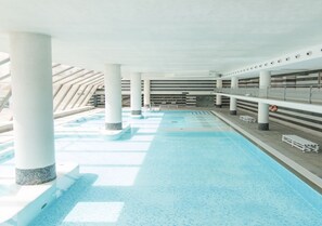 An indoor swimming pool with clear water, white columns, and a tiled floor. - Albergue Inturjoven & Jaen - Hostel (Jaén)