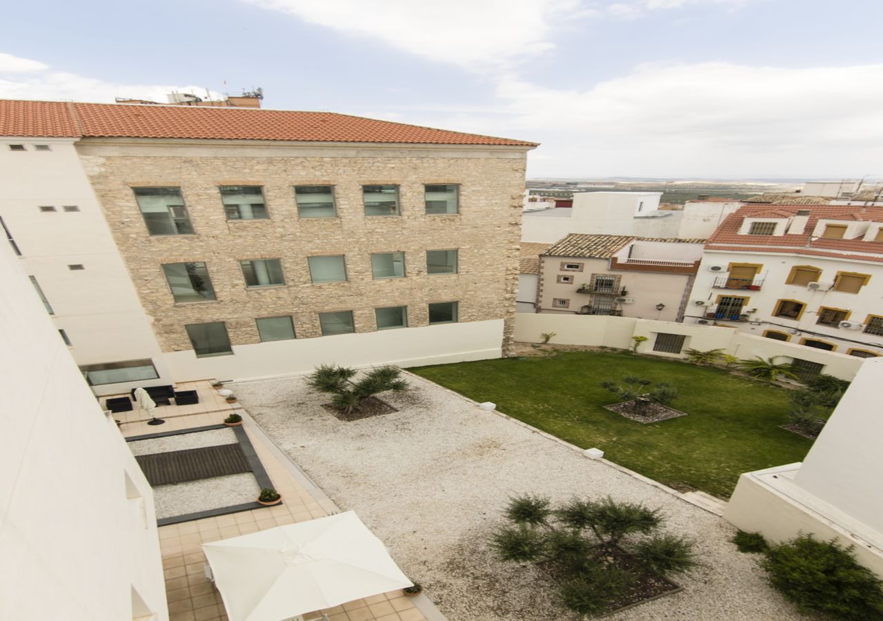 A courtyard with a building featuring multiple windows and a tiled roof.