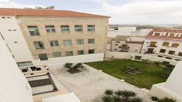 A courtyard with a building featuring multiple windows and a tiled roof.