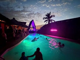 Una piscina al aire libre, sombrillas, sillones reclinables de piscina