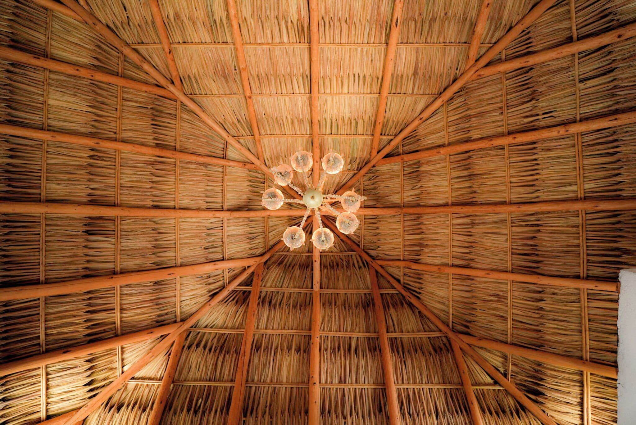 A room with a thatched roof and wooden beams.