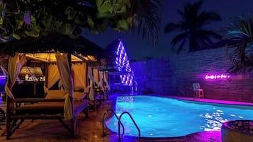 Una piscina al aire libre, sombrillas, sillones reclinables de piscina