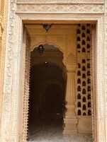 An ornate entrance with intricate carvings and a series of arches leading into a dimly lit interior.