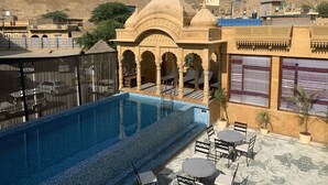 Zona de piscina con vistas a una fortaleza histórica al fondo.